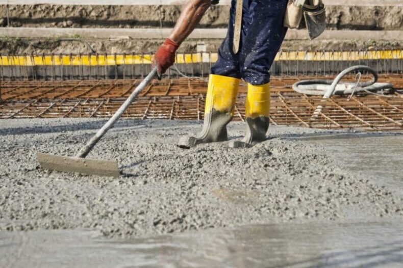 a bricklayer who level the freshly poured concrete to lay the foundations of a building e1628826568848 roofing contractor